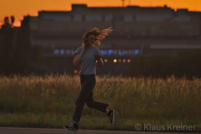 Ende Juni 2019 in Berlin: Eine Frau in der Auseinandersetung mit einem Junikäfer an einem Sommerabend auf dem Tempelhofer Feld.