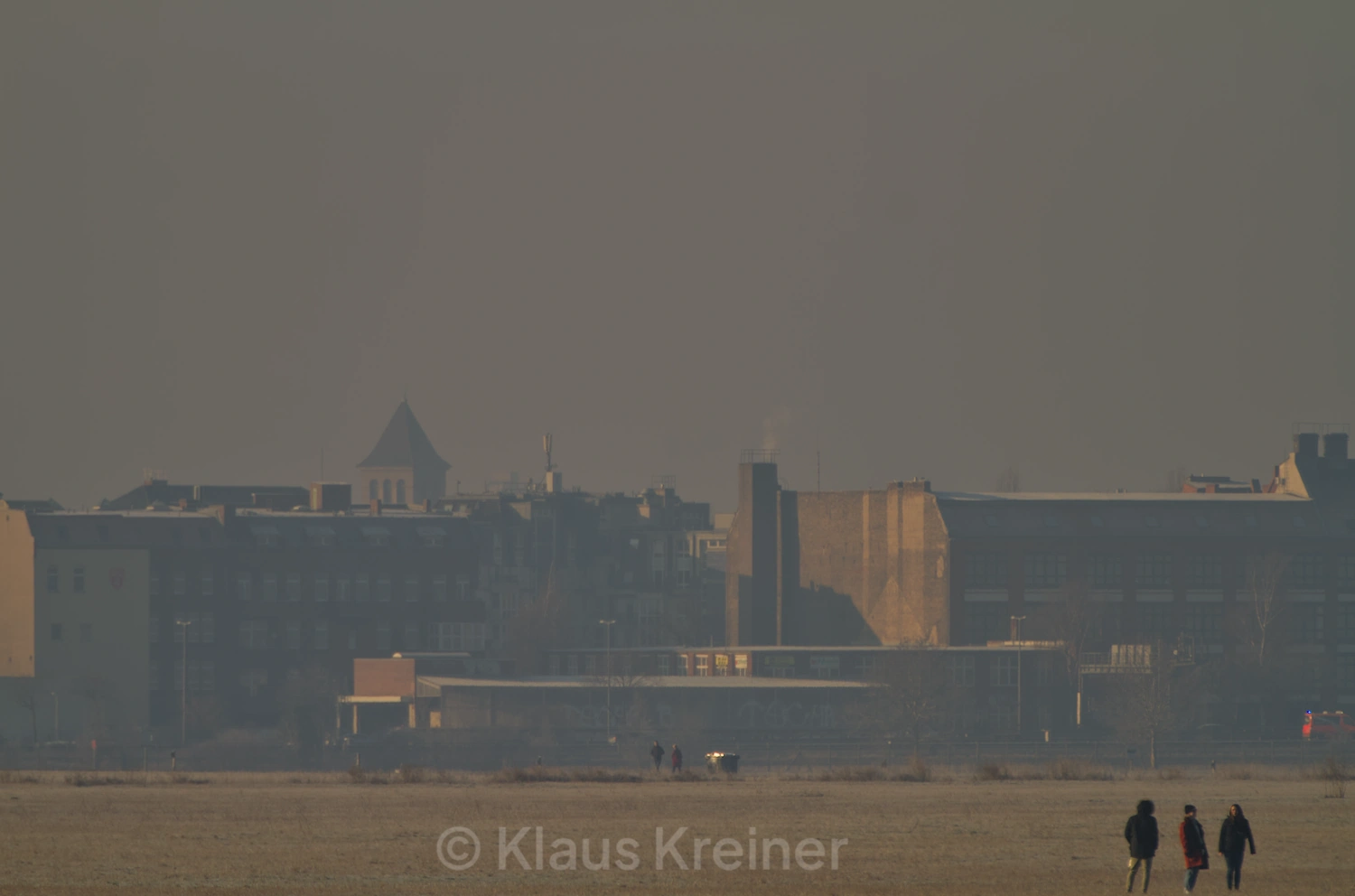 Ende Januar 2019 in Berlin: Eine Menschengruppe an einem Wintermorgen auf dem Tempelhofer Feld vor einem urbanen Hintergrund.