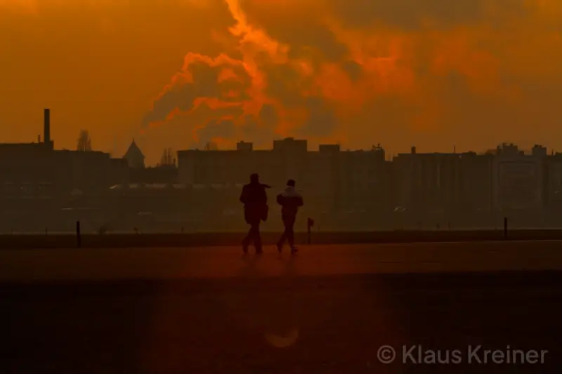 Ende Januar 2019 in Berlin: Im Sonnenuntergang kämpfen Menschen gegen den Wind auf der Rollbahn eines stillgelegten Flughafens.