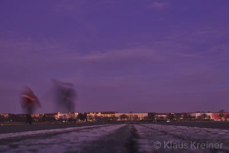 Ende Februar 2019 in Berlin: Länger belichtet und damit leicht verwischt rennen zwei Menschen auf der Piste eines stillgelegten Flughafens.