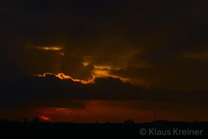 Ende Januar 2021 in Berlin: Eine vom Abendrot erstrahlte dunkle Wolkenfront legt sich imposant über eine Skyline der Hauptstadt.