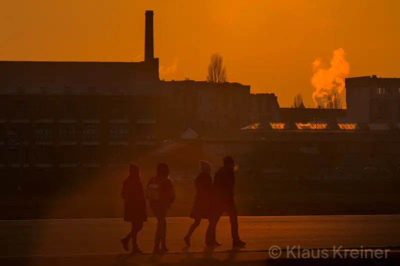 Ende Januar 2019 in Berlin: Eine Menschengruppe im Sonnenuntergang auf der Rollbahn eines stillgelegten Flughafens in Berlin-Tempelhof.