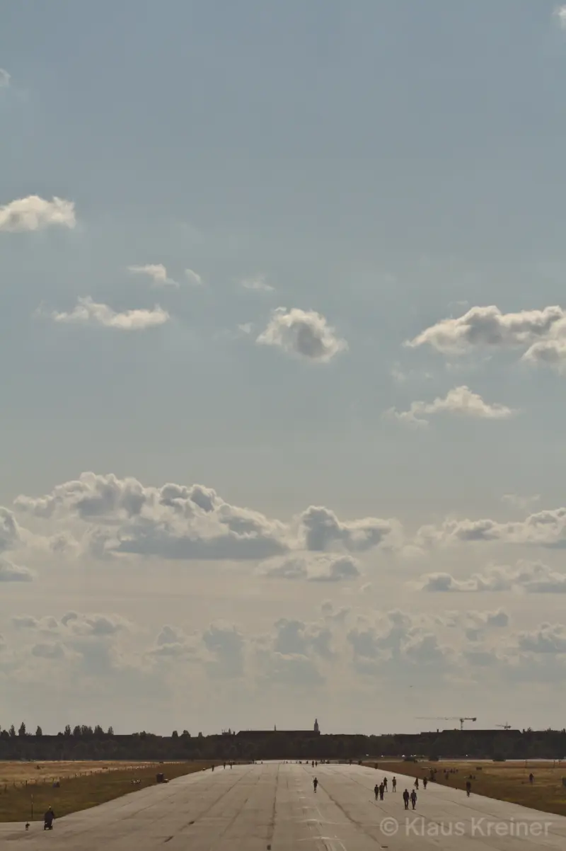 Anfang Juli 2019 in Berlin: Mehrere Menschen laufen bei sommerlichem Wetter über eine der Rollbahnen vom Tempelhofer Feld.