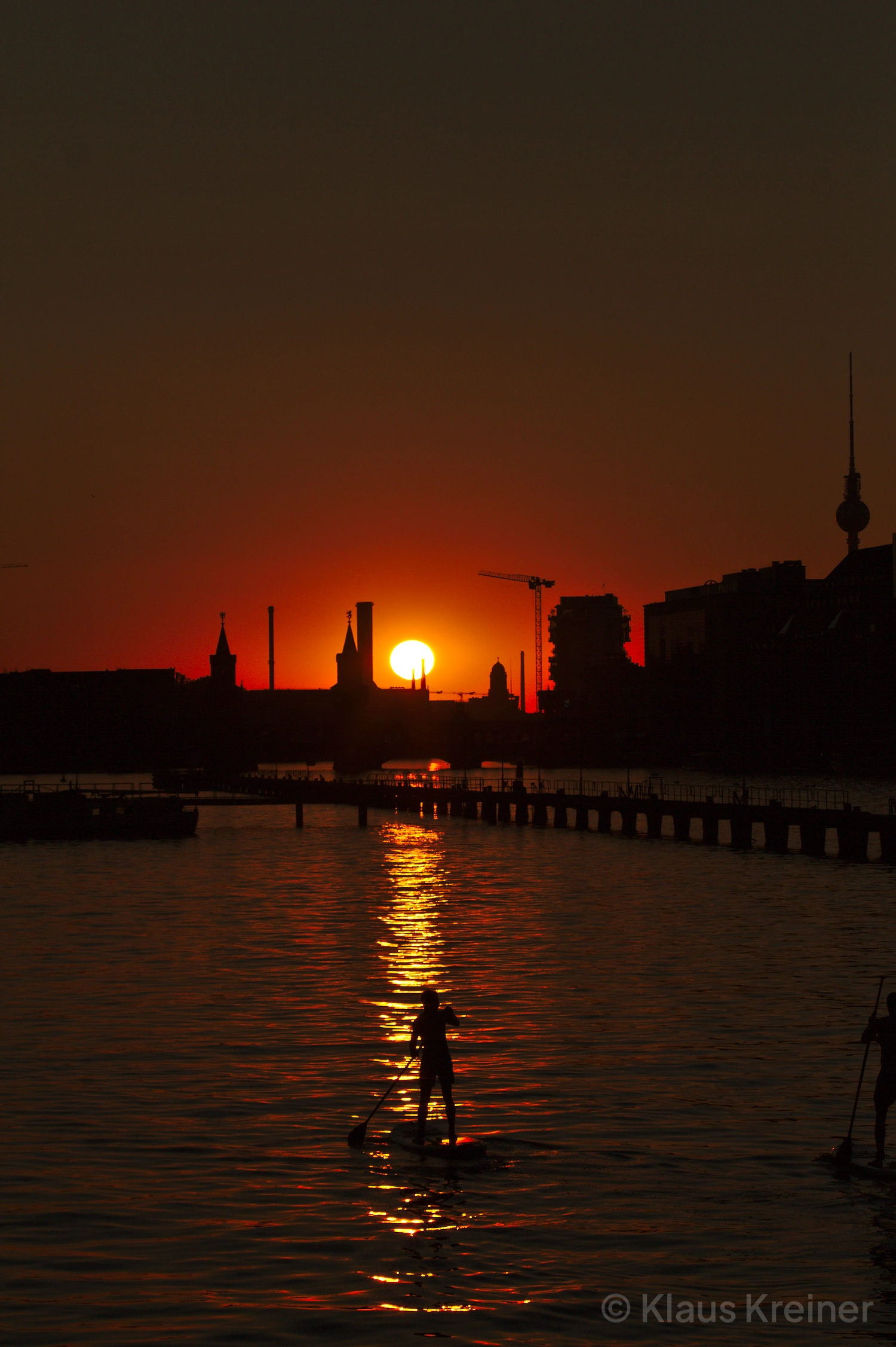 Ende Juli 2019 in Berlin: An einem Spätsommerabend gleitet ein Standup-Paddler über das Wasser an der Oberbaumbrücke.