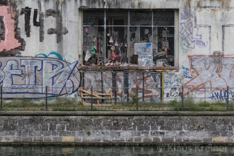 Anfang Oktober 2023 in Berlin: Ein vergittertes und vermülltes Verlies unterhalb vom Mauerweg am Berlin-Spandauer-Schifffahrtskanal in Mitte.