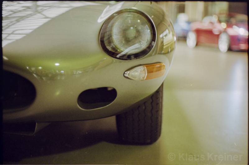 Ein Jaguar-E-Type in der Remise, während sich im Hintergrund weitere Oldtimer tummeln.